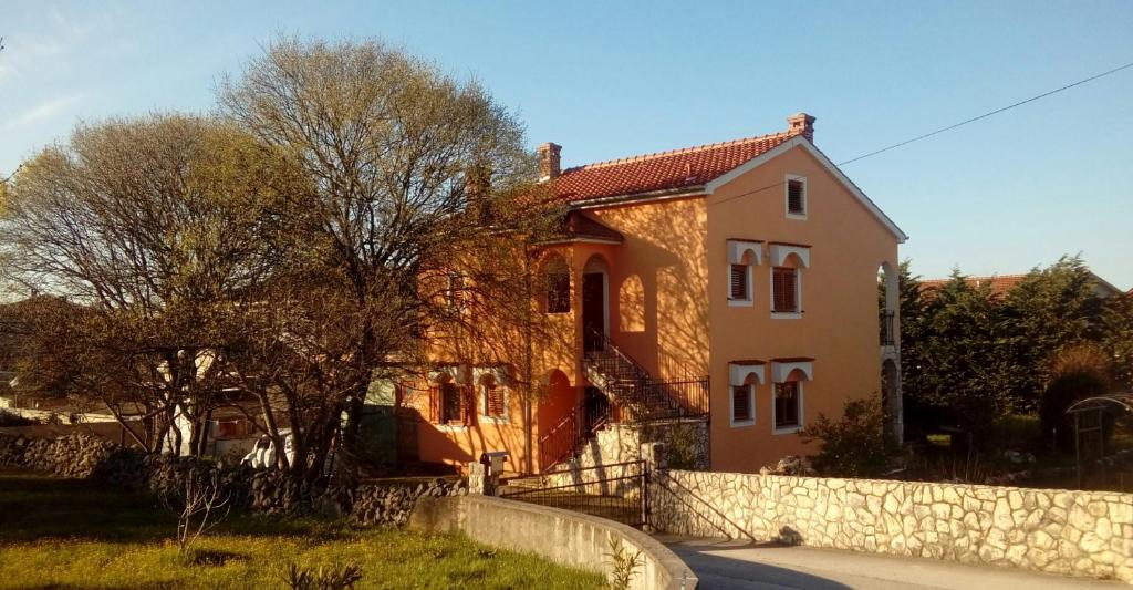 a house with a stone fence in front of it at Apartments Laura in Pinezici