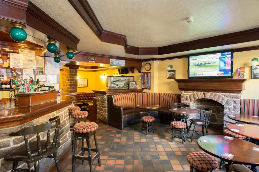 a restaurant with tables and chairs and a fireplace at Larkin's Pub, Restaurant, and B&B in Milltown