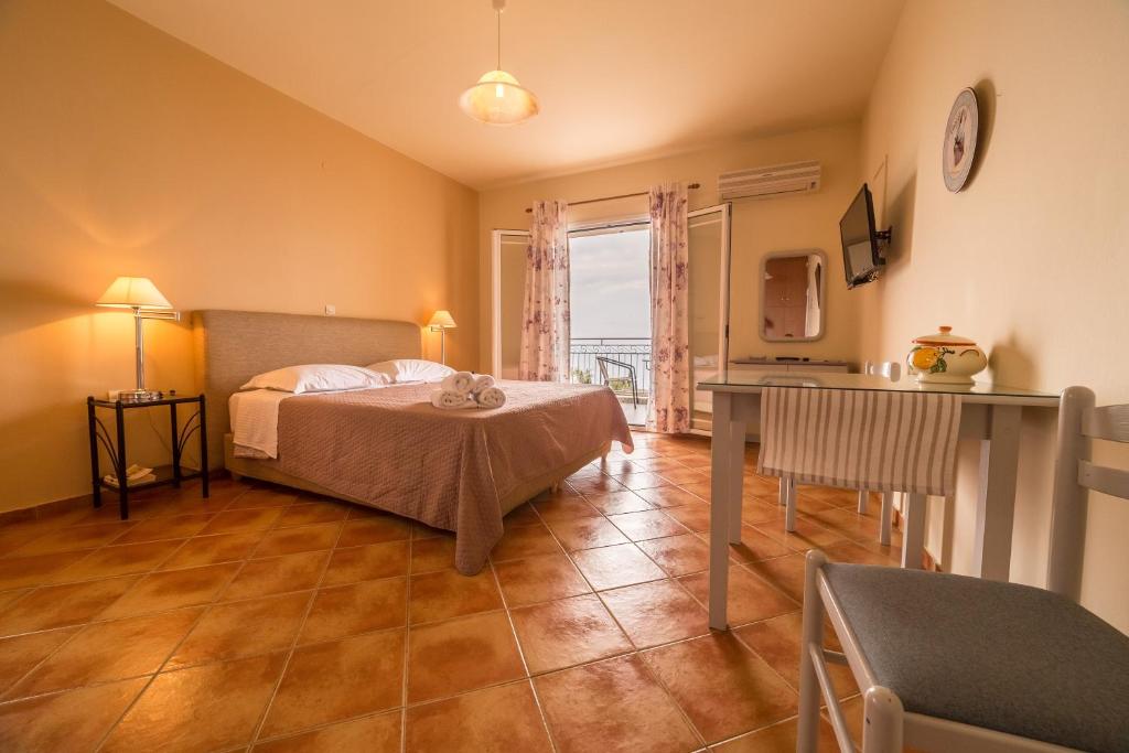 een slaapkamer met een bed, een tafel en een raam bij Delfinia in Vlachata