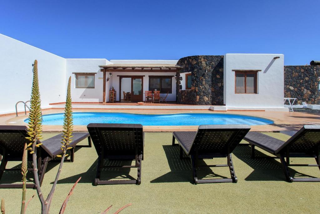 Villa con piscina, sillas y casa en Casa MINA, en La Oliva