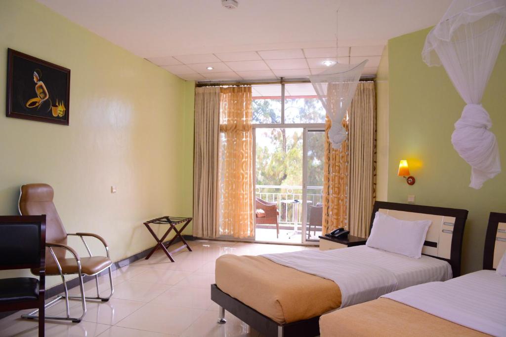 a hotel room with two beds and a balcony at Beausejour Hotel in Kigali