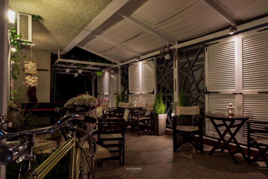 a restaurant with tables and chairs and a bike at Electra Apartments & Studios in Keramotí