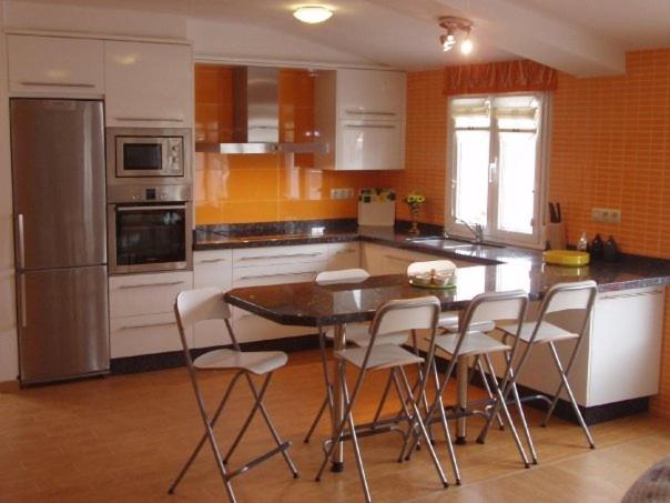 uma cozinha com uma mesa e cadeiras em Ático nuevo en playa de Laxe em Laxe