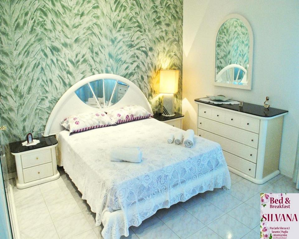 sypialnia z dużym łóżkiem z białą narzutą w obiekcie Bed and Breakfast Silvana w mieście Tarent