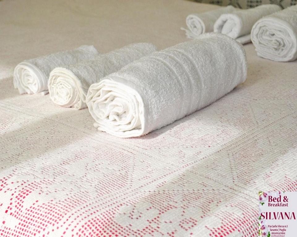 grupa składanych ręczników na łóżku w obiekcie Bed and Breakfast Silvana w mieście Tarent