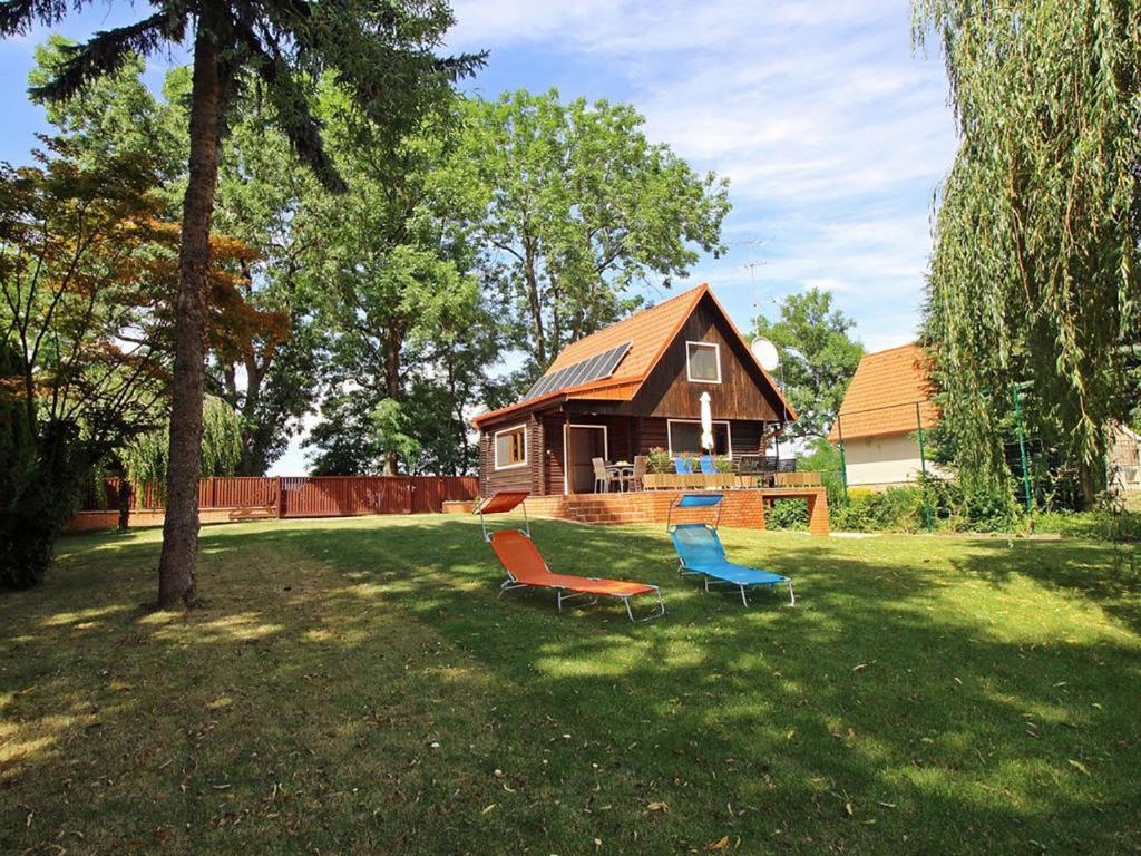 two chairs sitting in the grass in front of a house at Dunaparti Ház Stand u 27E in Mosonmagyaróvár