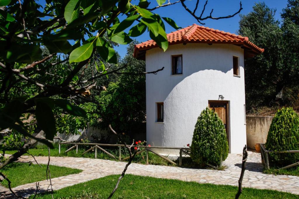 a small white building with a red roof at Kefalonian Mill - Oneira Villas in Trapezaki