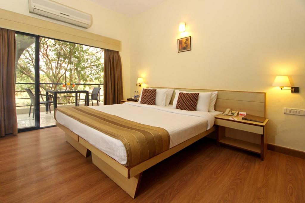 Postel nebo postele na pokoji v ubytování Hotel Phoenix Koregaon Park
