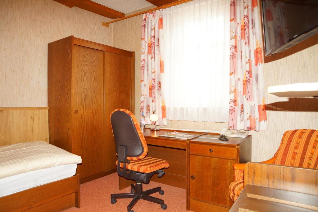 a bedroom with a desk and a chair and a bed at Hotel zum Schiffchen in Wolfhagen