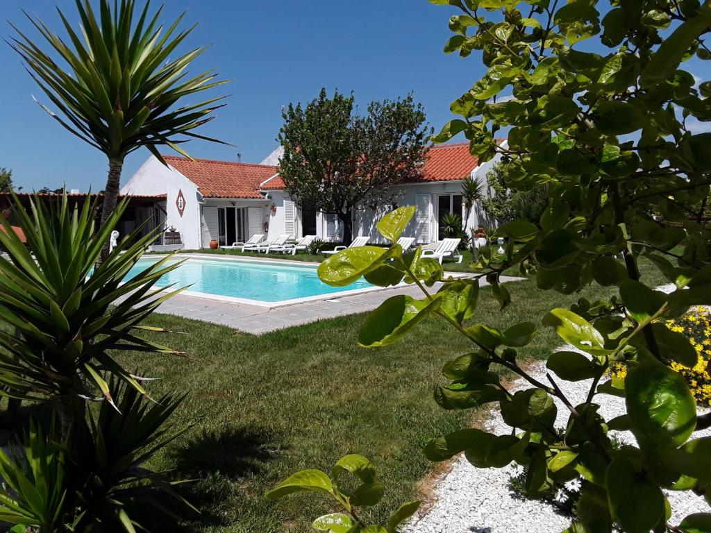 une arrière-cour avec une piscine et une maison dans l'établissement Quinta Camargue, à Cela Velha