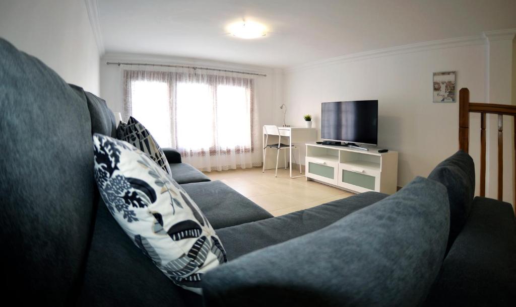 a living room with a couch and a tv at Iriarte Serenity with FREE PARKING in Puerto de la Cruz