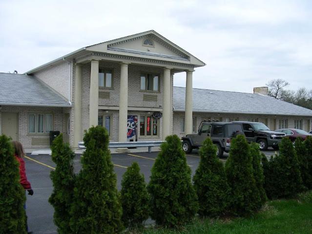 Uma mulher está em frente a um edifício. em D-Lux Budget Inn Lemont em Lemont