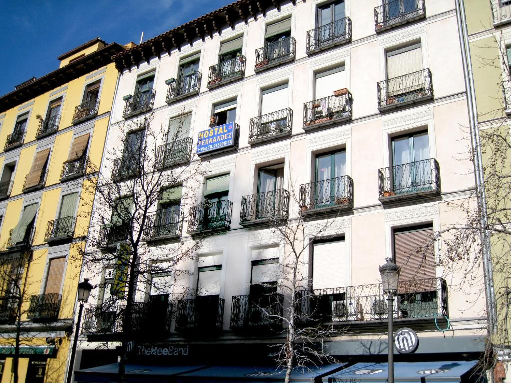 ein weißes Gebäude mit Balkon in einer Stadtstraße in der Unterkunft Hostal Residencia Fernandez in Madrid