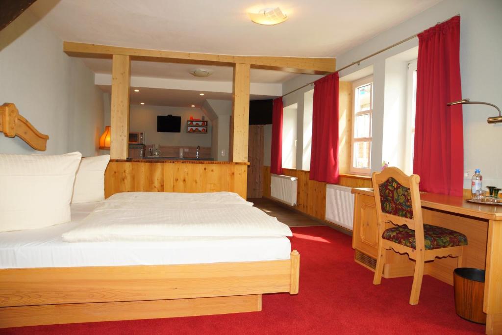 a bedroom with a wooden bed and a desk with a desk at Hotel zum Schiffchen in Wolfhagen