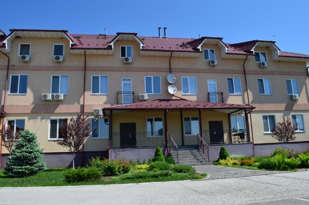 a large apartment building with a staircase in front of it at SunLake Hotel Osokorki in Kyiv