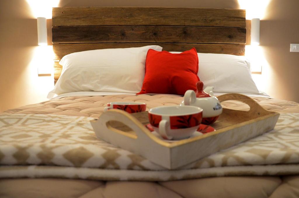 a tray with cups and mugs on a bed at B&B Al borgo in Frascati