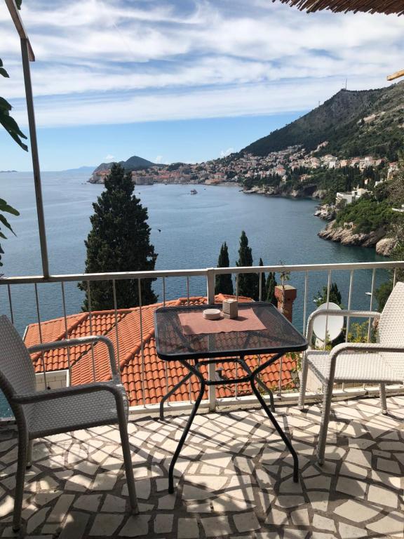 una mesa y sillas en un balcón con vistas al agua en Guest Accommodation Sveti Jakov en Dubrovnik