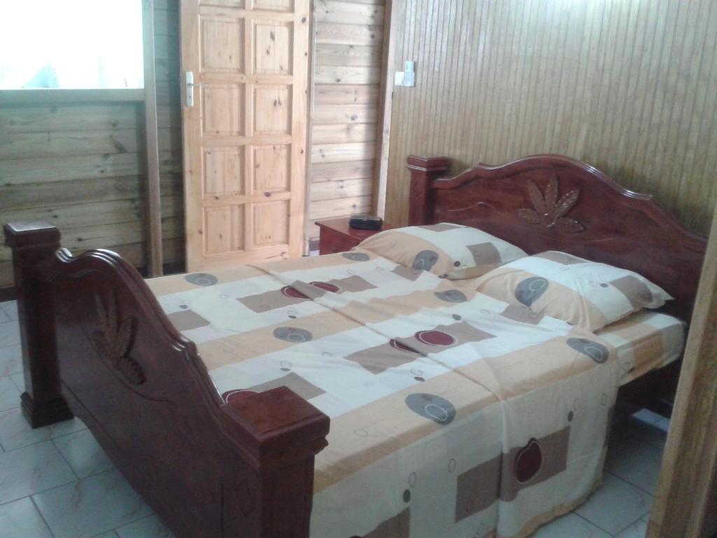a wooden bed in a room with at La Belle Creole in Morne-à-lʼEau