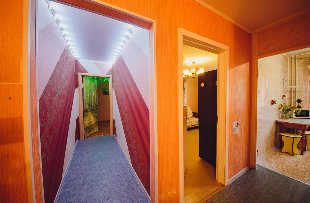 ヤロスラヴリにあるАпартаменты на улице Чкалова,82аのオレンジ色の壁の廊下、部屋につながる廊下