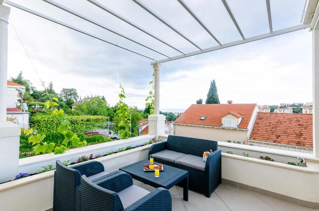 eine Terrasse mit blauen Stühlen und einem Tisch auf dem Balkon in der Unterkunft Miracle Apartments in Dubrovnik