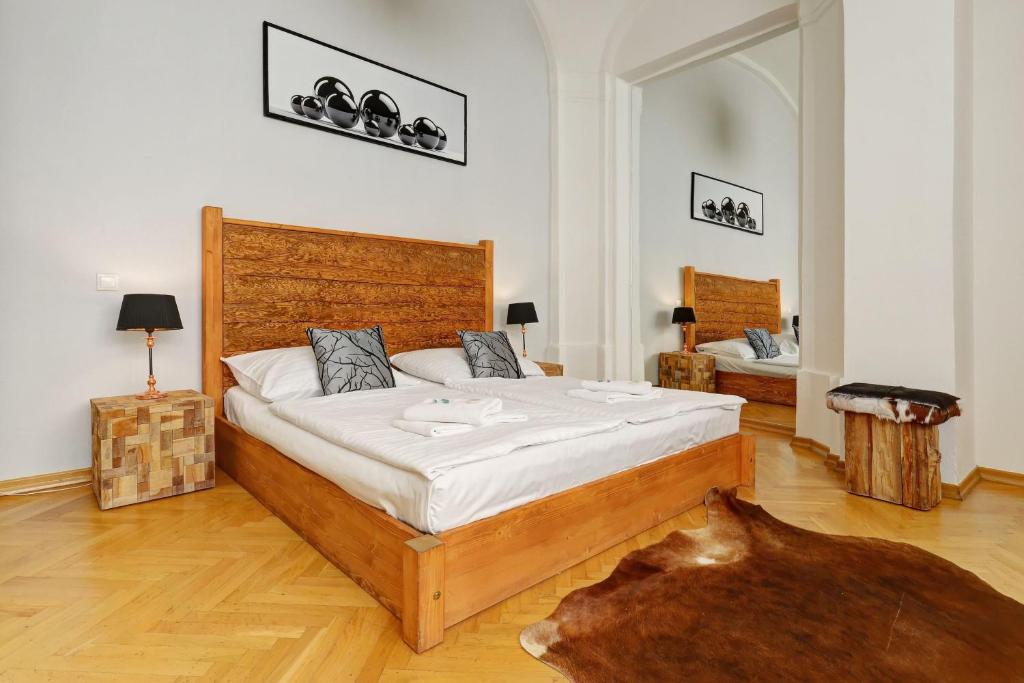 a bedroom with a large bed with a wooden headboard at Historic Centre Apartments VII in Prague