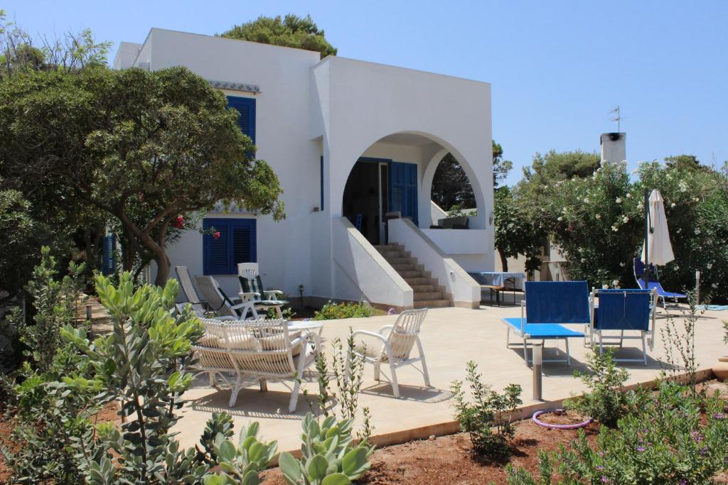 a patio with chairs and tables in front of a building at Villa Casa Madre in San Vito lo Capo