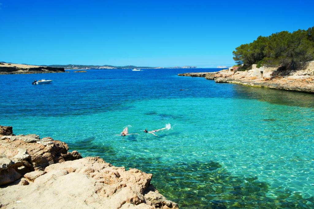 a group of people swimming in a body of water at Cubanito Ibiza in San Antonio