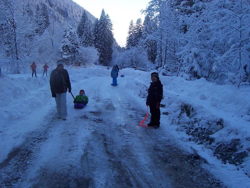 a group of people walking down a snow covered road at Le Bivouac in Sixt