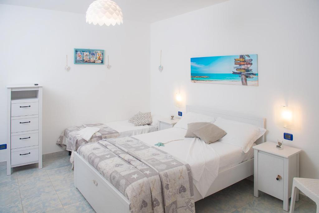 a bedroom with two beds and a dresser at Hotel San Giovanni in Polignano a Mare