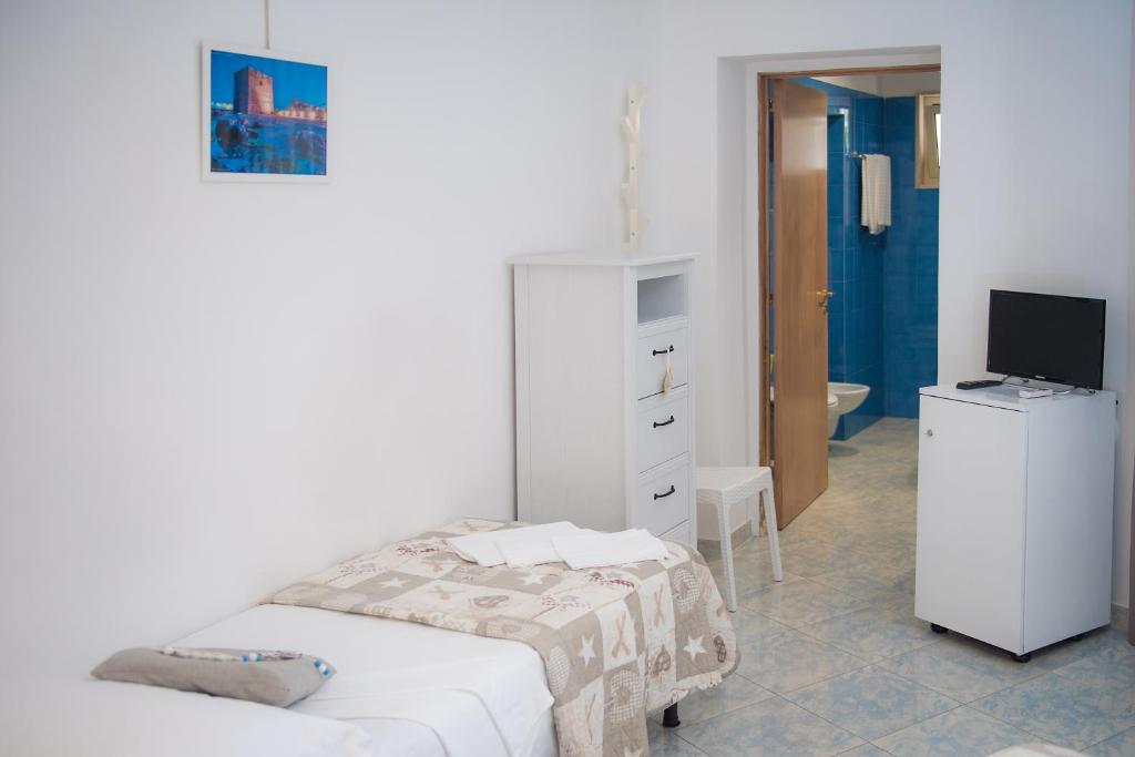 a bedroom with two beds and a television in it at Hotel San Giovanni in Polignano a Mare
