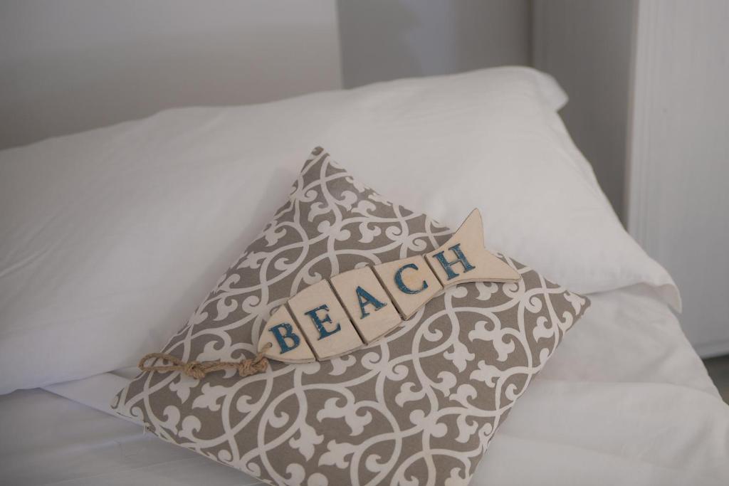 a pillow with a sign on it on a bed at Hotel San Giovanni in Polignano a Mare