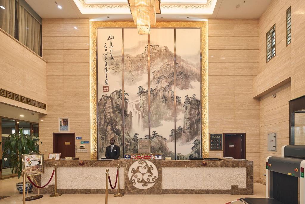 a large painting on the wall of a lobby at Soluxe Hotel Niamey in Niamey