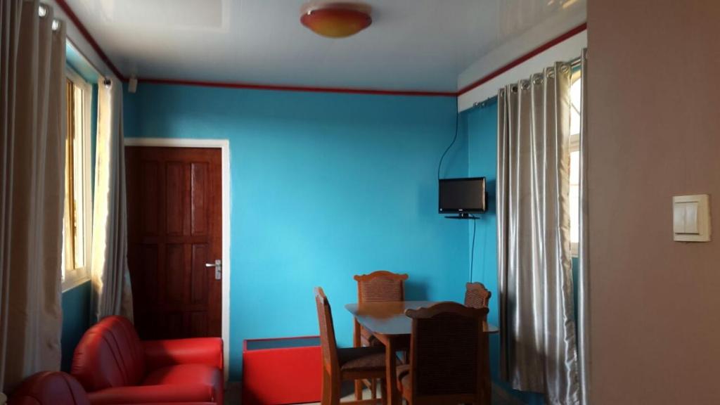 a dining room with blue walls and a table and chairs at Splendora Apartment, Suriname, Wanica in Flora