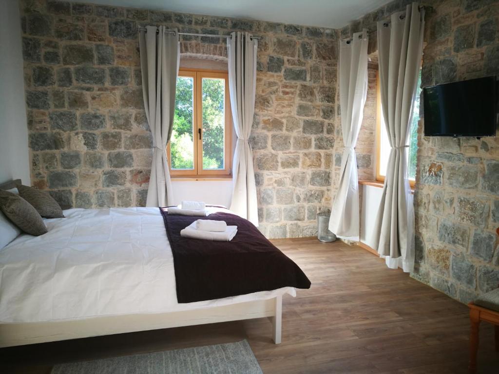 a bedroom with a bed and a brick wall at Villa Sol in Kaštela