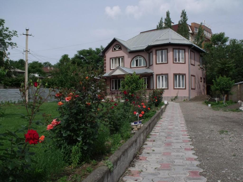 a pink house with a walkway in front of it at Hostel Visit Osh in Osh