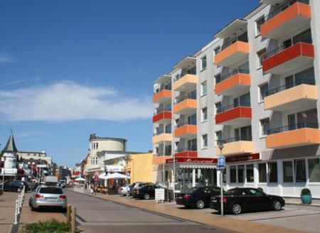 a street with cars parked in front of a building at Hotel Dünenburg in Westerland (Sylt)