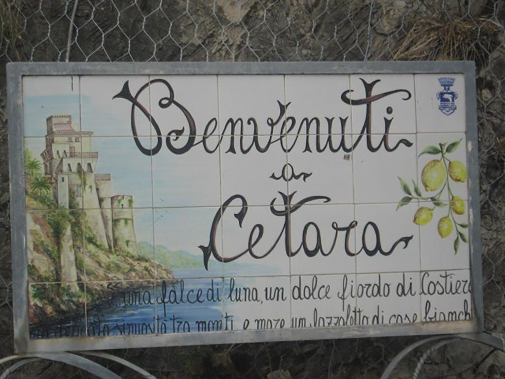 a sign on a fence with a painting of a castle at ApartHotel Gasba in Cetara