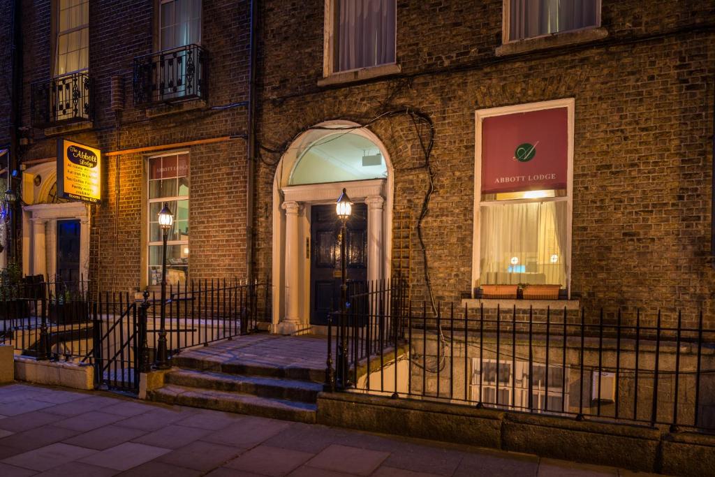 a brick building with a black door on a street at Abbott Lodge in Dublin