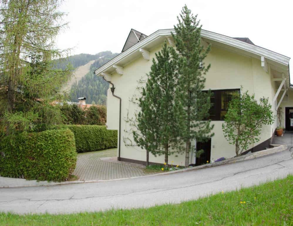 ein weißes Haus mit Bäumen und einer Auffahrt in der Unterkunft ISIS---Ferienwohnung in Steinach am Brenner