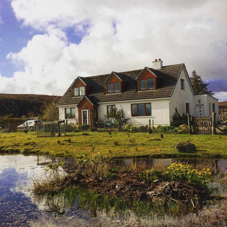 a house with a pond in front of it at The Lovecroft Guest House in Laide