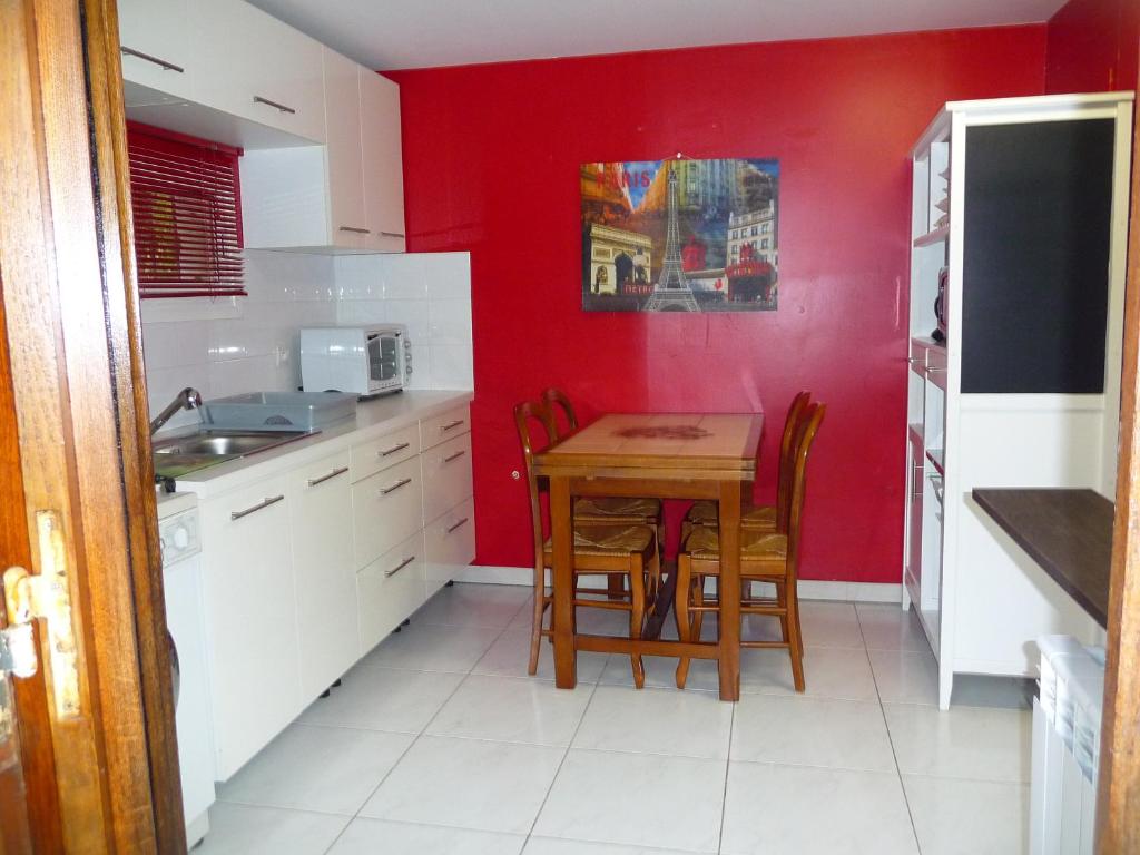 ナン・レ・パンにあるMas des Sentes Dépendanceの赤い壁のキッチン(テーブル付)