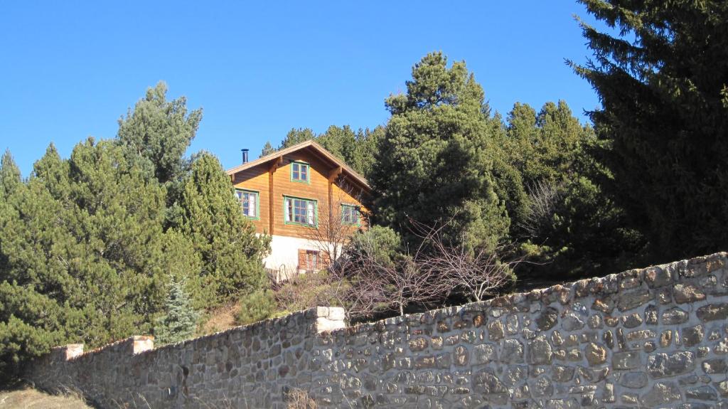 une maison sur une colline derrière un mur de pierre dans l'établissement Chalet Finlandais, à Bolquère-Pyrénées 2000