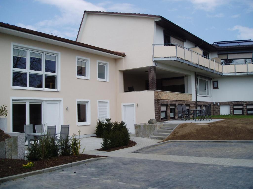 a white house with a balcony and a driveway at Haus Königshöhe in Grömitz