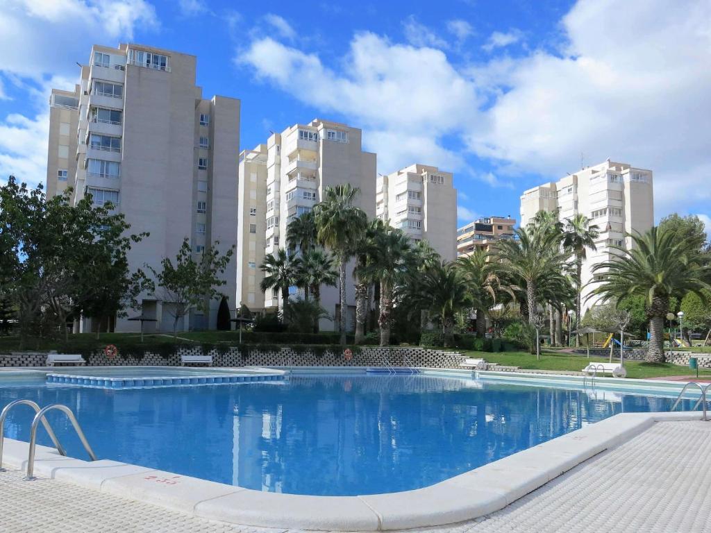 une grande piscine avec de grands bâtiments en arrière-plan dans l'établissement Villamar - Relax, Sol y Playa, à Alicante