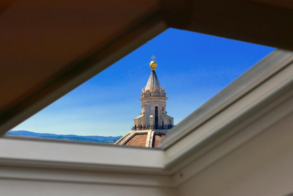 uma vista para a torre do relógio de um edifício em Elisa Guest House em Florença