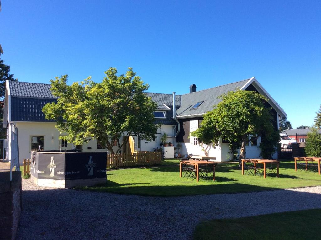 una casa con mesas de picnic en el patio en Gamla Bryggeriet Bed & Breakfast, en Köpingsvik