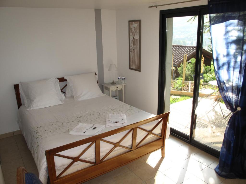 Schlafzimmer mit einem Bett und einer Glasschiebetür in der Unterkunft Les Terrasses de Rochetaillée in Rochetaillée
