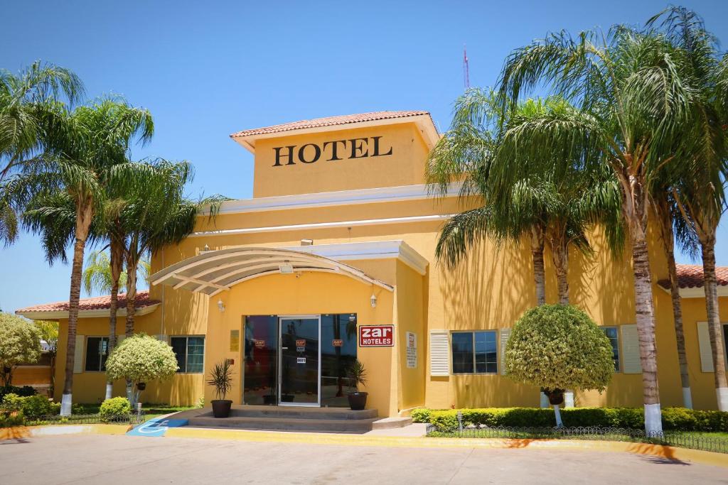 a hotel with palm trees in front of it at Zar Los Mochis in Los Mochis