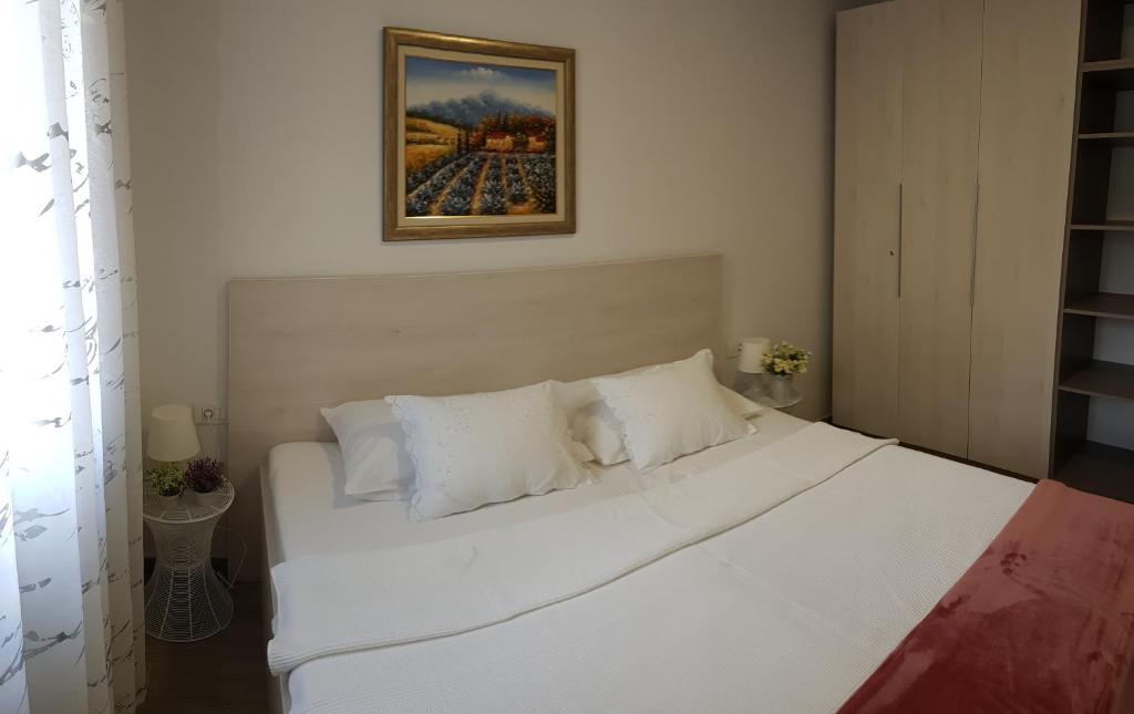 1 cama blanca con almohadas blancas en una habitación en Apartment Bart en Split