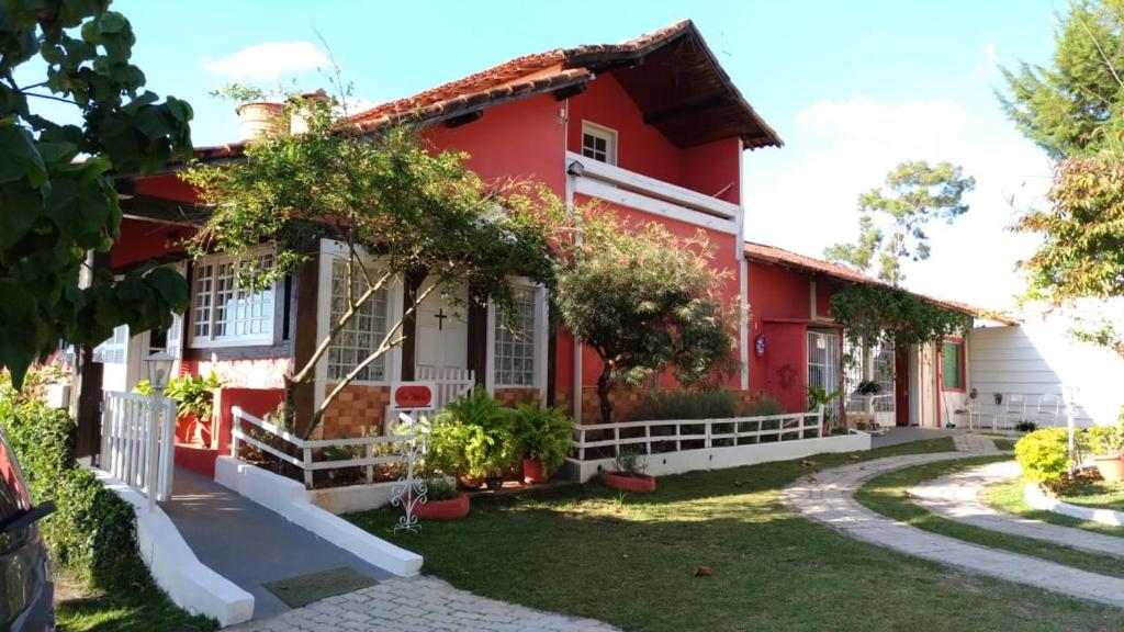 una casa rossa con un giardino di fronte di Pousada Calu a Cunha
